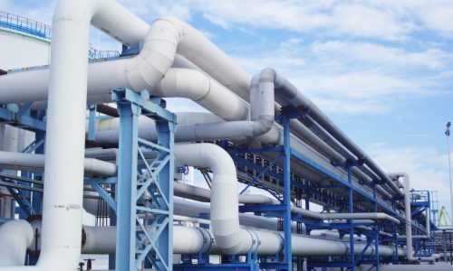 Closeup of industrial pipelines around a factor on a sunny day A closeup of industrial pipelines around a factor on a sunny day